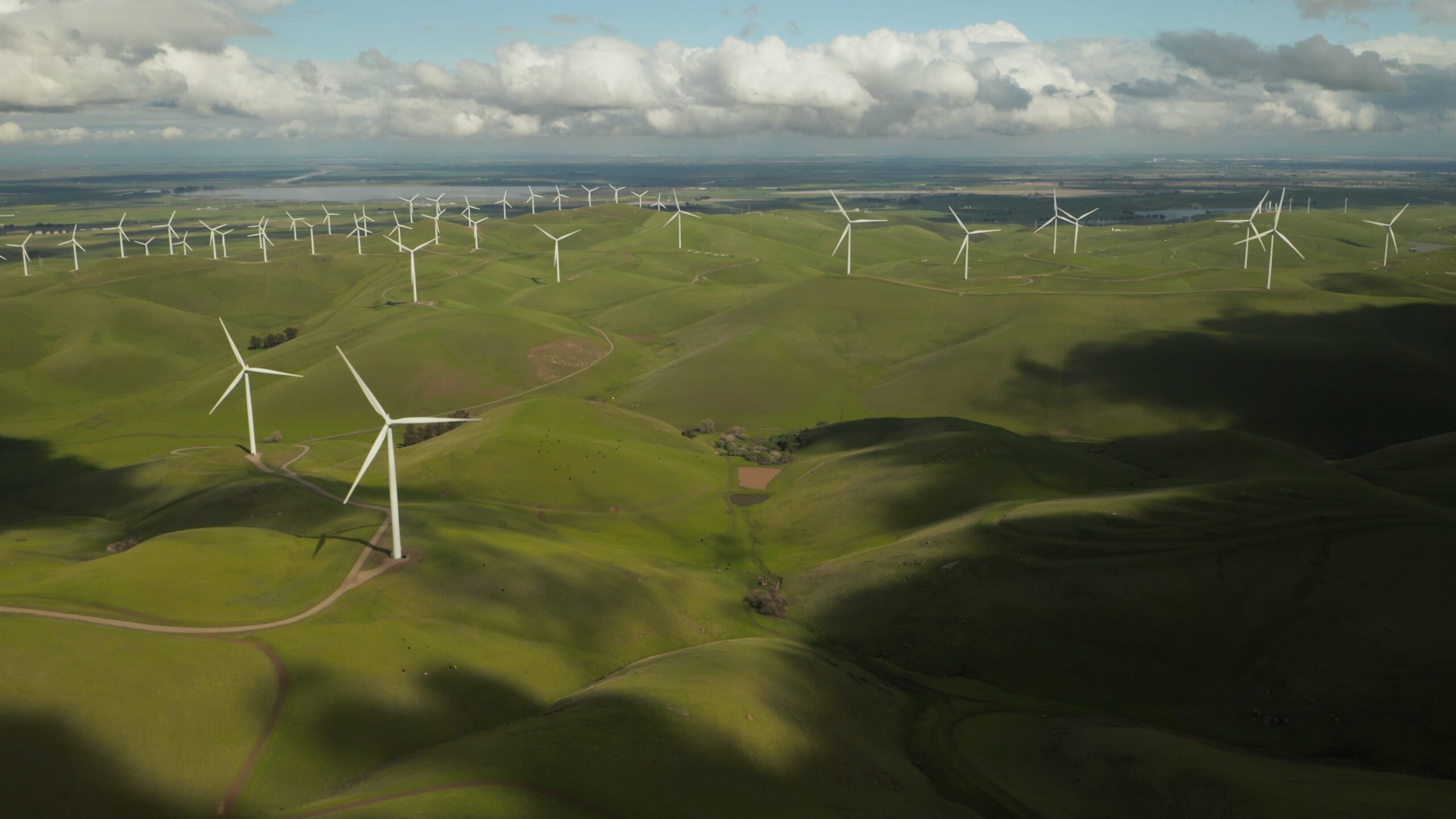 aerial view of windmills on rolling hills during a cloudy day